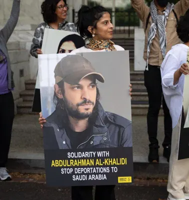 Amnesty International demonstrators holding a poster of Abdulrahman Al-Khalidi reading Stop deportations to Saudi Arabia